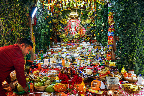 A priest arranges offerings to Goddess Lakshmi at a temple on the occasion of Dev Deepawali, in Ahmedabad.