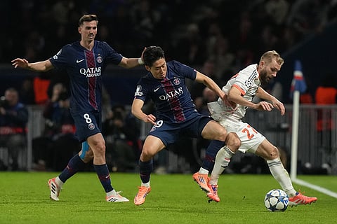 PSG's Kang-in Lee, center, and Bayern's Konrad Laimer challenge for the ball during the Champions League opening phase soccer match between Paris Saint-Germain and Bayern Munich in Paris, France.