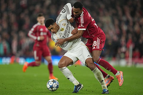 Liverpool's Ryan Gravenberch, right, and Real Madrid's Jude Bellingham fight for the ball during the Champions League soccer match between Liverpool and Real Madrid in Liverpool, England.