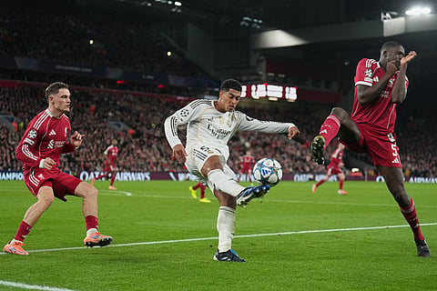 Real Madrid's Jude Bellingham kikcs the bal in front of Liverpool's Ibrahima Konate during the Champions League soccer match between Liverpool and Real Madrid in Liverpool, England.