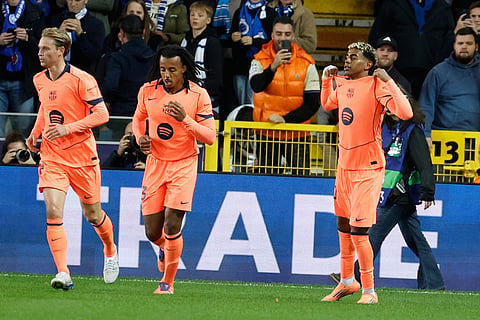 Barcelona's Lamine Yamal, right, celebrates after scoring his sides second goal during the Champions League opening phase soccer match between Club Brugge and Barcelona in Bruges, Belgium.