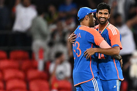 Washington Sundar, right, is congratulated by teammate Suryakumar Yadav after taking a wicket during a T20 cricket international between India and Australia in Carrara, Australia.