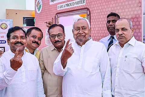 In this image, Bihar Chief Minister Nitish Kumar and others show their ink marked fingers after casting votes during the first phase of Bihar Assembly elections, at Bakhtiyarpur, in Patna district.