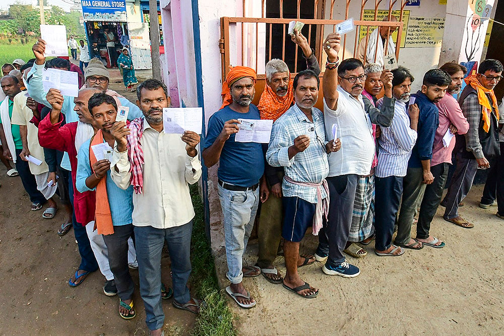 | PTI; Representational image : People show their credentials as they wait in a queue to cast votes at a polling station during the first phase of Bihar Assembly elections, in Patna. 
