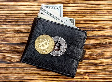 Crypto Wallet with bitcoin coins on a wooden table