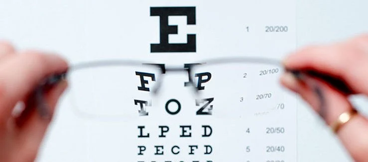 a person looking through glasses at the eye test poster