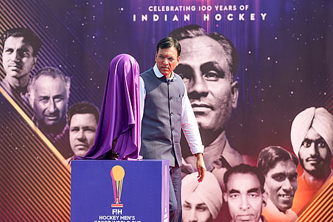 Union Minister for Sports Mansukh Mandaviya walks past the covered Men's Junior Hockey World Cup trophy during the Hockey India centenary celebrations, at Major Dhyan Chand National Stadium, in New Delhi.