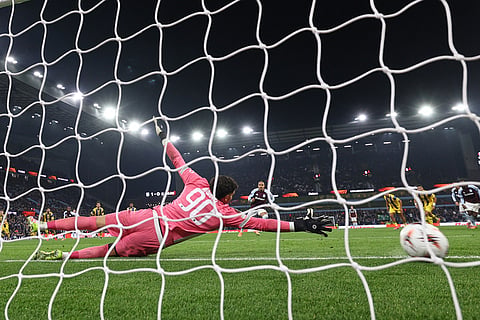 Maccabi Tel Aviv's goalkeeper Roi Mishpati dives but fails to save the goal from Aston Villa's Donyell Malen, centre, during the Europa League soccer match between Aston Villa and Maccabi Tel Aviv in Birmingham, England.