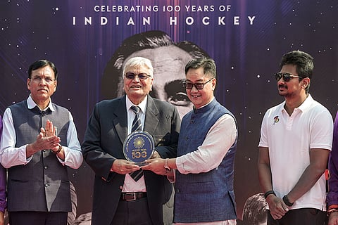 Union Sports and Youth Affairs Minister Mansukh Mandaviya, left, and Union Minister Kiren Rijiju, second right, felicitate former hockey player Aslam Sher Khan during an event marking 100 years of Indian Hockey, at Major Dhyan Chand National Stadium, in New Delhi.