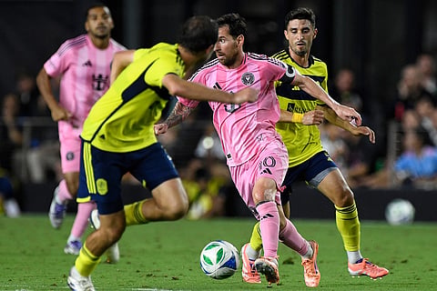 Inter Miami forward Lionel Messi, center right, dribbles past Nashville SC defender Jack Maher, center left, during the second half of Game 3 in the first round of MLS soccer's Western Conference playoffs in Fort Lauderdale, Florida.