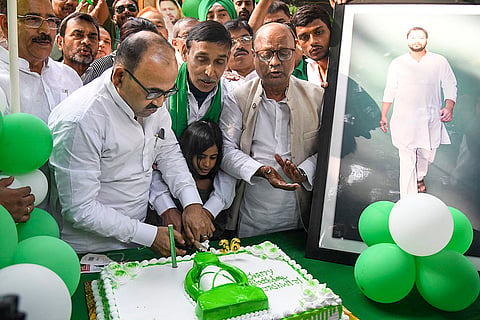 RJD supporters cut a cake on the occasion of the party leader and Leader of Opposition in Bihar Assembly Tejashwi Yadav's birthday at the party office, in Patna.