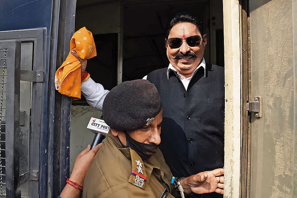 Land of the gangster-legislator: RJD MLA Anant Singh being detained by a police official on November 25, 2020, in Patna - | Photo: Imago/Hindustan times