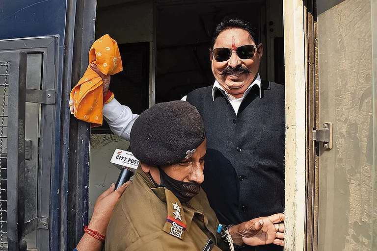 Land of the gangster-legislator: RJD MLA Anant Singh being detained by a police official on November 25, 2020, in Patna - | Photo: Imago/Hindustan times