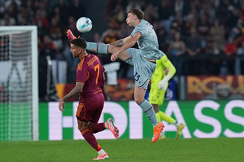 Udinese's Nicolo Bertola, right, reaches for the ball ahead of Roma's Lorenzo Pellegrini during the Serie A soccer match between Roma and Udinese, in Rome.