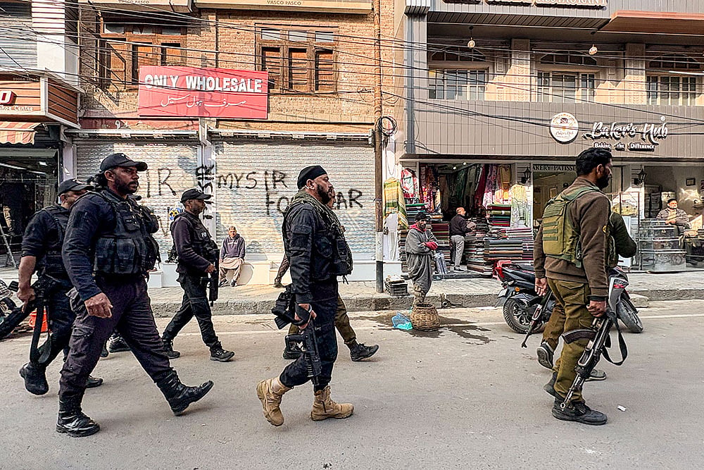 Photo: PTI : Security personnel stand guard following the arrest of Dr. Adeel (a resident of Wanpora, Kulgam), accused in an interstate and transnational terror module, in Anantnag. The arrest and subsequent terror module bust were results of a joint operation by the Faridabad and Jammu and Kashmir Police. 