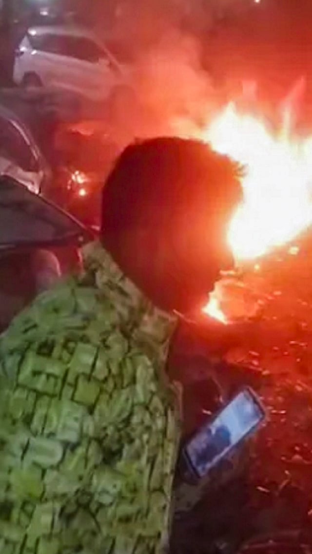 A man rushes away from the spot after a blast occurred in a parked car near Red Fort, leaving multiple vehicles in flames, in New Delhi. - | Photo: PTI