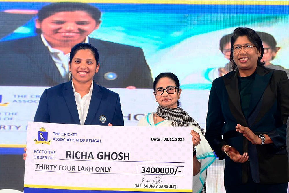 | Photo: @AITCofficial/X via PTI : In this image posted, West Bengal Chief Minister Mamata Banerjee felicitates Richa Ghosh, member of the Women's ODI World Cup 2025-winning Indian cricket team, during a felicitation ceremony at Eden Gardens, in Kolkata. Former cricketer Jhulan Goswami is also seen.