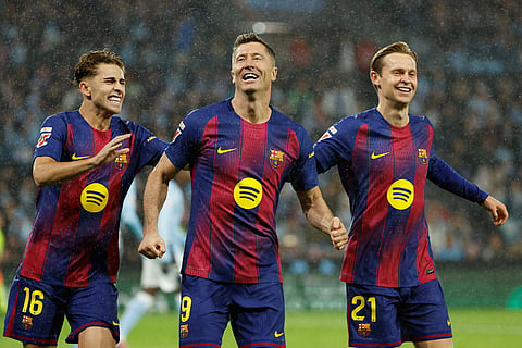 Barcelona's Robert Lewandowski, center, celebrates scoring his side's opening goal from the penalty spot during the Spanish La Liga soccer match between Celta Vigo and Barcelona in Vigo, Spain.