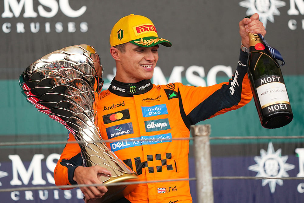 | Photo: AP/Andre Penner : McLaren driver Lando Norris of Britain celebrates on the podium his first place in the Brazilian Formula One Grand Prix at the Interlagos race track in Sao Paulo.