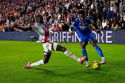 Real Madrid's Vinicius Junior, right, is challenged by Rayo's Nobel Mendy during a Spanish La Liga soccer match between Rayo Vallecano and Real Madrid in Madrid, Spain.