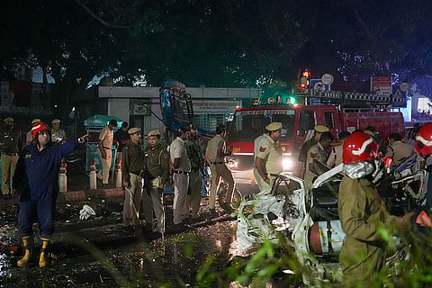 Police personnel at the spot after a blast occurred in a parked car near Red Fort, leaving multiple vehicles in flames, in New Delhi.