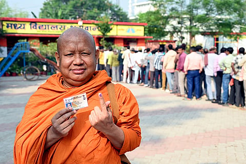 A buddhist monk shows his ink-marked finger after casting his vote during the second and final phase of the Bihar Assembly elections, in Gaya.