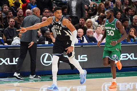 Milwaukee Bucks forward Giannis Antetokounmpo (34) reacts after scoring a 3-point basket against Dallas Mavericks center Moussa Cisse (30) during the second half of an NBA basketball game in Dallas.