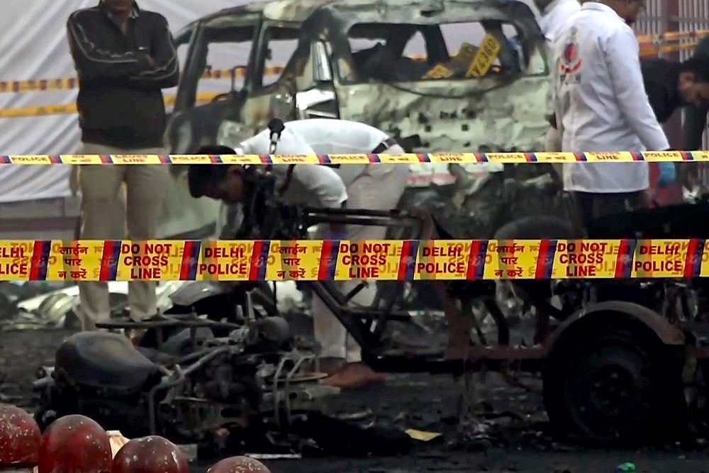 | Photo: PTI : Charred remains of vehicles amid a cordoned off area following a blast that occurred near Red Fort Metro Station on Monday, killing at least nine people and gutting several vehicles, in New Delhi.
