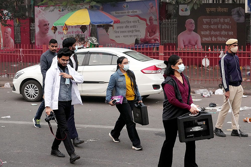 Photo: PTI/Kamal Kishore : Forensic officials at the site in the aftermath of the blast that occurred near Red Fort Metro Station on Monday, killing at least nine people and gutting several vehicles, in New Delhi.