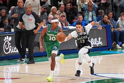 Milwaukee Bucks guard Ryan Rollins (13) and Dallas Mavericks guard Brandon Williams (10) chase the ball during the second half of an NBA basketball game in Dallas.