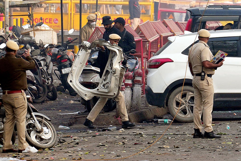 Photo: PTI/Kamal Kishore : Police personnel at the site in the aftermath of the blast that occurred near Red Fort Metro Station on Monday, killing at least nine people and gutting several vehicles, in New Delhi.
