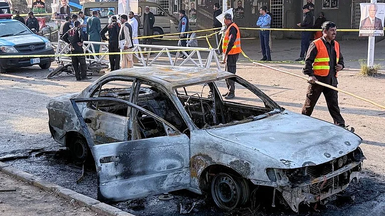 Security officials and rescue workers gather at the site following a suicide bombing outside the gates of a district court, in Islamabad, Pakistan. - AP