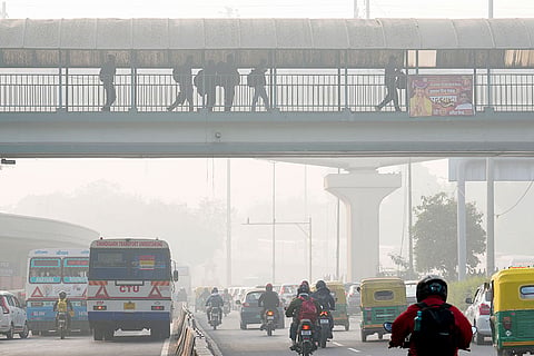 A thick layer of smog shrouds the city road as the Air Quality Index (AQI) remains in the poor category, near ISBT in New Delhi.