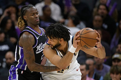 Sacramento Kings guard Keon Ellis, left, guards Denver Nuggets guard Jamal Murray during the second half of an NBA basketball game in Sacramento, California.