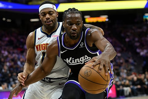 Sacramento Kings forward Precious Achiuwa, right is guarded by Denver Nuggets guard Bruce Brown during the second half of an NBA basketball game in Sacramento, California.