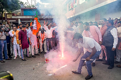 BJP workers celebrate as the NDA alliance leads during the counting of votes for the Bihar Assembly elections, at the party office in Lucknow.
