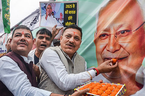 JDU members celebrate as the NDA alliance leads during the counting of votes of the Bihar Assembly elections, in Patna.