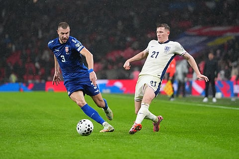 Serbia's Strahinja Pavlovic, left, and England's Elliot Anderson fight for the ball during a World Cup qualifier group K soccer match between Serbia and England in London.