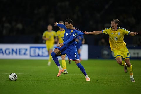 Ukraine's Yehor Yarmoliuk fights for the ball against France's Hugo Ekitike during a World Cup 2026 group D qualifying soccer match between France and Ukraine in Paris.