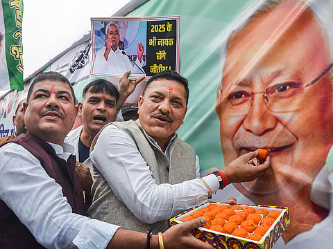 JDU members celebrate as the NDA alliance leads during the counting of votes of the Bihar Assembly elections, in Patna.
