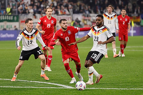 Luxembourg's Danel Sinani, center, fights for the ball with Germany's Ridle Baku, center right, and Germany's Florian Wirtz, left, during the 2026 World Cup group A qualifying soccer match between Luxembourg and Germany in Luxembourg.