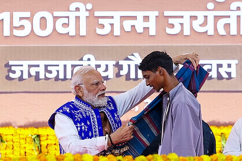 Prime Minister Narendra Modi felicitates a young man during an event marking the 150th birth anniversary of tribal icon Bhagwan Birsa Munda celebrated as 'Janjatiya Gaurav Divas', in Dediapada, Narmada district, Gujarat. 