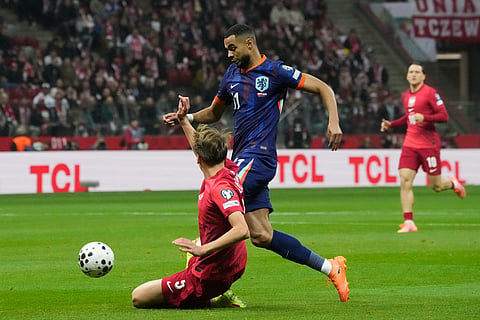Poland's Jan Ziolkowski, left, tries to tackle Netherlands' Cody Gakpo during a World Cup 2026 group G qualifying soccer match between Poland and the Netherlands in Warsaw.