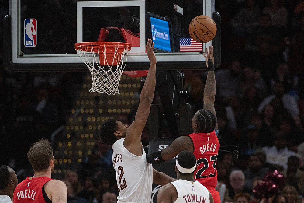 | Photo: AP/Phil Long : Toronto Raptors' Jamal Shead (23) shoots over Cleveland Cavaliers' De'Andre Hunter (12) as Nae'Qwan Tomlin looks on during the second half of an NBA basketball game in Cleveland.