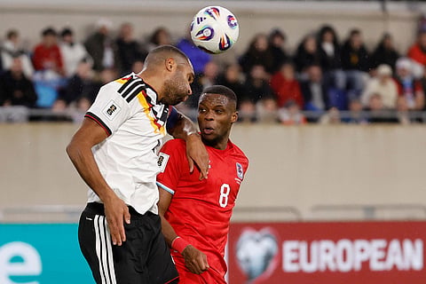 Germany's Jonathan Tah, left, goes up against Luxembourg's Christopher Martins during the 2026 World Cup group A qualifying soccer match between Luxembourg and Germany in Luxembourg.