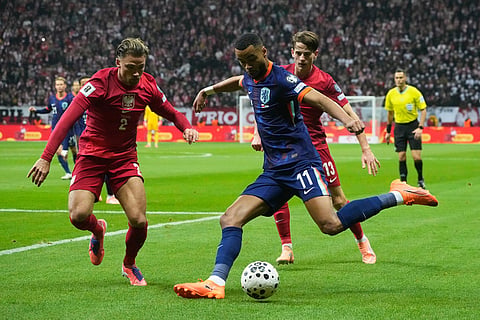 Netherlands' Cody Gakpo attempts a shot past Poland's Matty Cash, left, during a World Cup 2026 group G qualifying soccer match between Poland and the Netherlands in Warsaw.