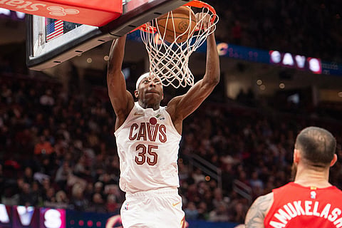 Cleveland Cavaliers' Nae'Qwan Tomlin (30) dunks as Toronto Raptors' Sandro Mamukelashvili, right, looks on during the second half of an NBA basketball game in Cleveland.