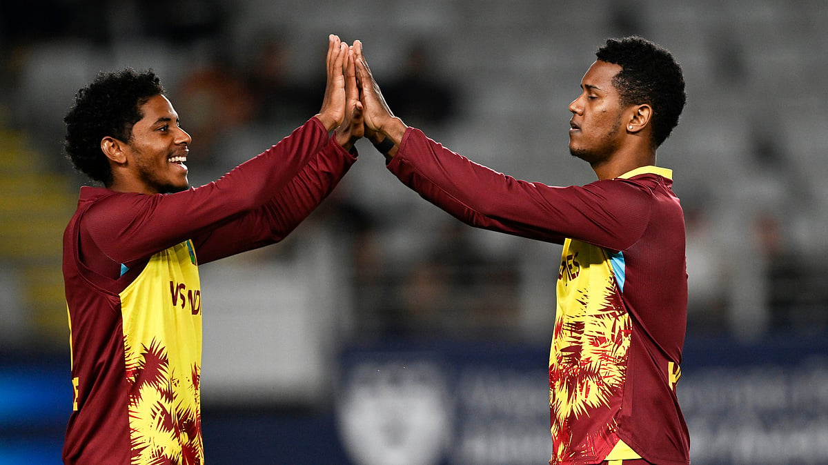 (Andrew Cornaga/Photosport via AP) : West Indies bowler Akeal Hosein celebrates with teammate Ackeem Auguste after taking the wicket of New Zealand's Sachin Ravindra during the T20 cricket international between New Zealand and the West Indies in Auckland, New Zealand, Wednesday, Nov. 5, 2025.