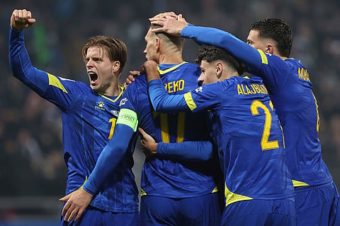 Bosnia's Edin Dzeko, centre back to the camera, celebrates with Dzenis Burnic, left, and other teammates after scoring his side's opening goal during the 2026 World Cup Group H qualifier soccer match between Bosnia and Romania in Zenica, Bosnia and Herzegovina.
