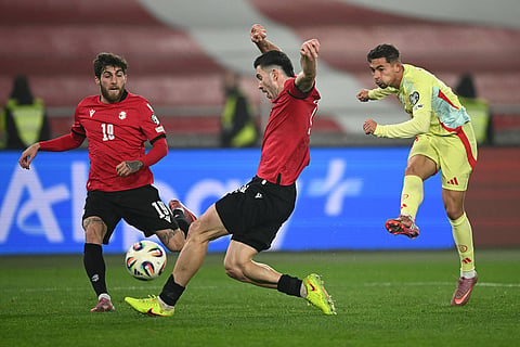 Spain's Yeremy Pino, right, kicks the ball as Georgia's Luka Lochoshvili, centre, tries to stop him during a World Cup 2026 group E qualifying soccer match between Georgia and Spain in Tbilisi, Georgia.